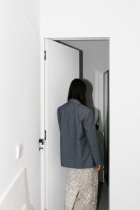 Kaboompics - Hard Flash Photography of Woman Walking Through White Doorway
