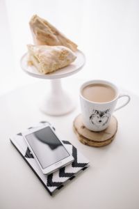 Creative Workspace Still Life: Smartphone, Geometric Stationery, Pencil Jars, Coffee and Pastries