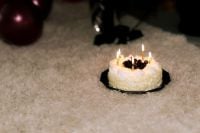 Kaboompics - Candlelit Birthday Cake on Carpet with Nostalgic Party Mood