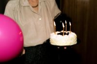 Kaboompics - Woman Holding Birthday Cake in a Nostalgic Party Setting