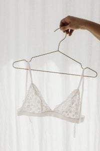 Kaboompics - White Lace Bralette Hanging from a Wire Hanger