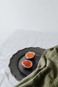 Kaboompics - Vertical Fig Still Life on Black Stoneware with Open Linen Space for Food Branding