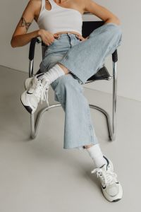 Kaboompics - Cross-Legged Pose in Wide-Leg Jeans and White Sneakers, Women’s Casual Outfit Styling
