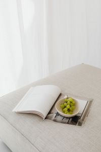 Kaboompics - Open Magazine and Grapes on a Sunlit Neutral Couch