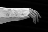 Kaboompics - White Shirt Sleeve and Hand Against a Black Background