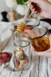 Kaboompics - Honey Drizzle over Sliced Fruit and Pomegranate in a Jar