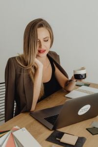 Kaboompics - Woman Holding Coffee Beside Open Laptop