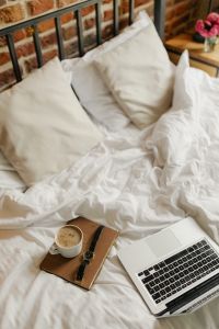 Kaboompics - Unmade White Bed with Laptop and Coffee, Cozy Work From Home Scene