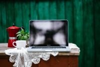 Kaboompics - Laptop Workspace With Red Moka Pot Against Green Wood