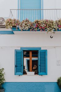 Kaboompics - White House with Blue Shutters and Flower-Filled Balcony
