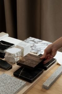 Kaboompics - Hand Arranging Wood and Black Marble Samples with Natural Stone