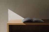 Kaboompics - Open book on oak wooden shelf with natural sunlight shadow