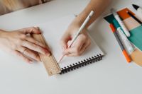Kaboompics - Graphic Designer Drawing with Pastel Pencil beside Wooden Ruler and Color Palette