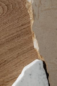 Kaboompics - Gray-Veined Marble Fragment with a Chipped Edge on Wood