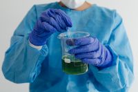 Kaboompics - Scientist Stirring Green Liquid in Laboratory Beaker