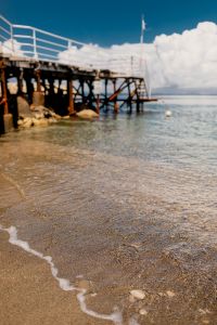 Kaboompics - Vertical Seaside Pier and Clear Water with Pebble Shore in the Foreground