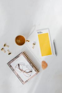 Kaboompics - Top view of a marble desk with coffee, notebooks and pen
