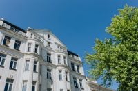 Kaboompics - Old white tenement house and green tree
