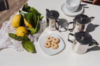 Kaboompics - Cups, silver jugs with coffee, Italian cookies and lemons on the table