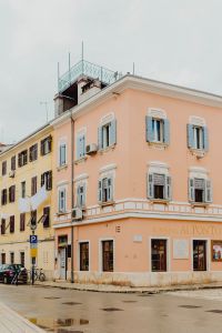 Kaboompics - Pastel Corner Building with Blue Shutters and Ornate Balcony in Rovinj