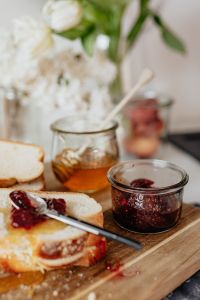 Kaboompics - Breakfast Table With Challah, Honey, Raspberry Jam, and White Flowers