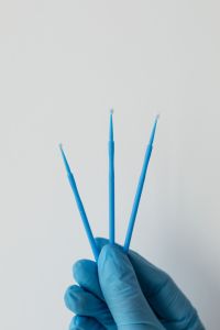 Kaboompics - Gloved Hand Holding Three Dental Microbrush Applicators