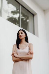 Kaboompics - Asian Woman in Pale Slip Dress with Arms Crossed beneath White Window