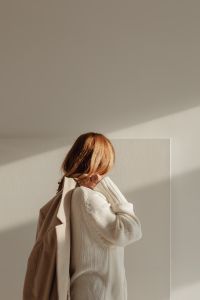 Kaboompics - Faceless Woman in White Sweater Wearing Beige Coat in Sunlight