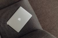 Kaboompics - Close up view of closed laptop lying on grey armchair
