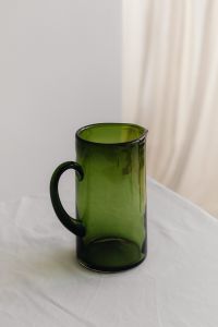 Kaboompics - Close-Up of a Green Glass Pitcher against a Soft Neutral Background