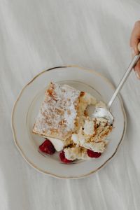 Kaboompics - Partially Eaten Napoleonka with Cream Crumbs and Raspberries on Plate