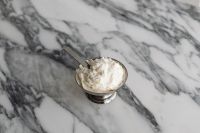 Kaboompics - White Cream Dessert in a Silver Bowl on Veined Arabescato Marble, Minimal Food Still Life
