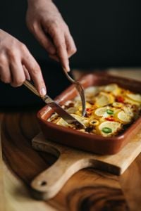 Kaboompics - Cutting Fish Casserole with Lemon in a Ceramic Dish