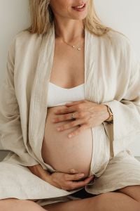 Kaboompics - Pregnant Woman in a White Robe Holding Her Belly