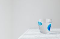 Kaboompics - Glass of Water Casting a Blue Shadow Across White Linen, Wide Copy Space Background