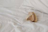 Kaboompics - Wooden Dry Body Brush on White Linen, Natural Spa Self-Care Background with Copy Space