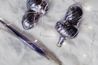Kaboompics - Silver and Purple Baubles Arranged on a White Textile