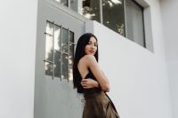 Kaboompics - Side Portrait of Asian Woman in Black Top and Brown Wrap Skirt beside White Wall