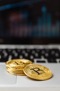 Kaboompics - Bitcoin Coins on Laptop Keyboard With Blue Chart