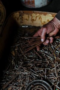 Kaboompics - Man grabbing a heap of rusty nails