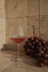 Kaboompics - Rose Wine Glass and Red Grapes in Stone Interior