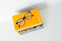 Kaboompics - Overhead Reading Glasses on a Yellow-Covered Book