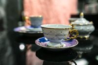 Kaboompics - White and Blue Teacup with Gold Handle on a Blue Saucer, Soft Pink Background