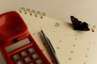 Kaboompics - May 2027 Calendar With Butterfly Red Telephone and Pen