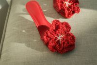 Kaboompics - Close-Up of a Red Sandal with Textured Crochet Flower on Gray Upholstery