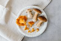 Kaboompics - Boletes and Chanterelles Arranged on a Speckled Plate