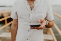 Kaboompics - Man Checking His Smartphone on a Lakeside Walkway