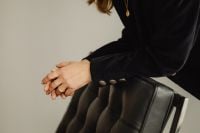 Kaboompics - Seated Woman Wearing Gold Rings and Necklace Beside Black Chair