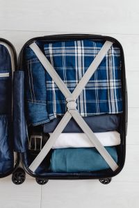 Holiday Packing Essentials: Open Suitcase with Folded Clothes, Denim, Shoes, Passport and Travel Accessories
