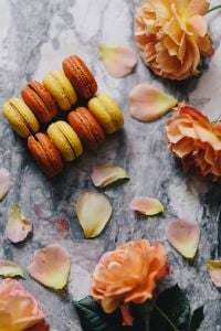 Kaboompics - Close-Up of Orange and Yellow French Macarons with Peach Roses on Marble